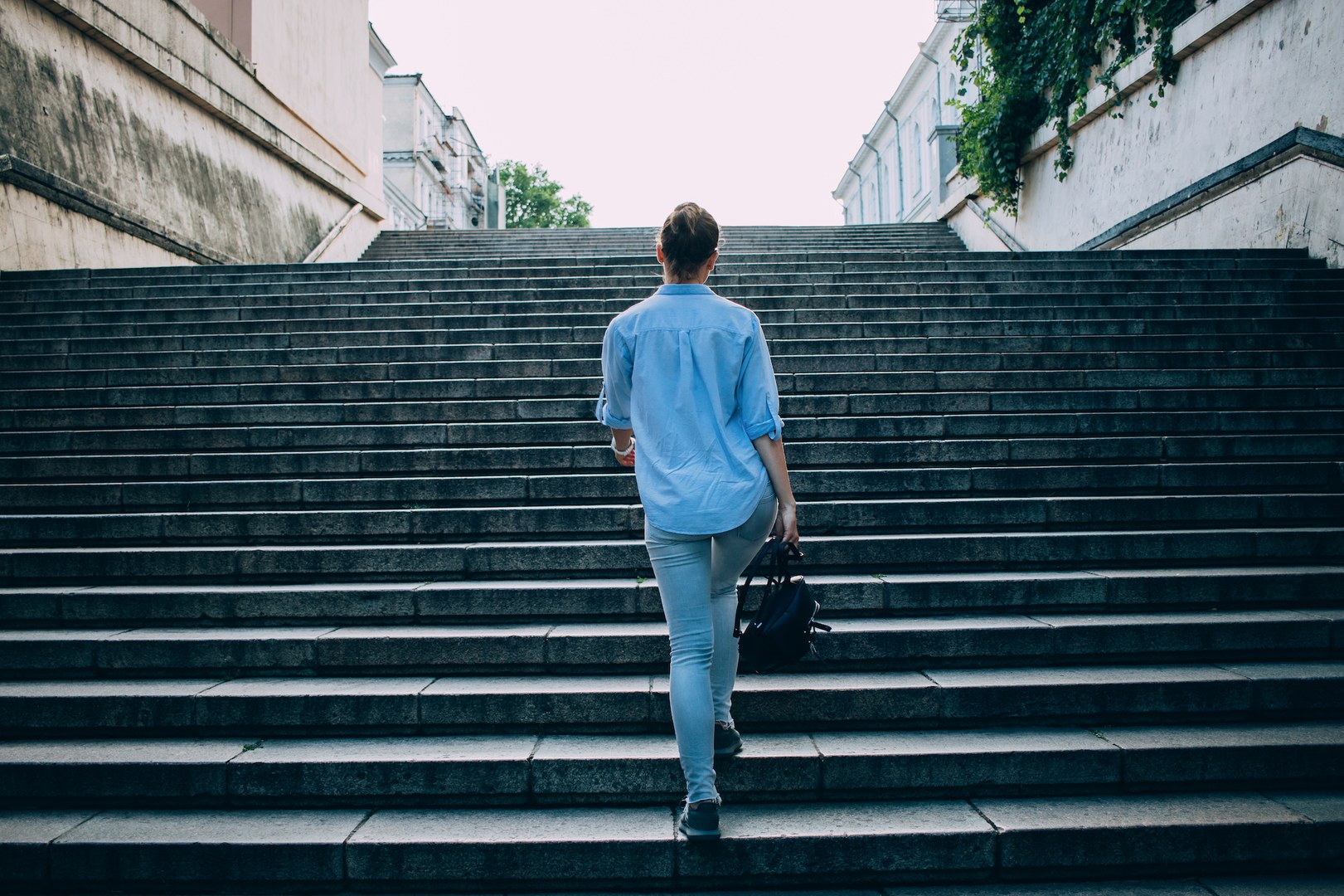 A woman seen from behind walking up a flight of stairs